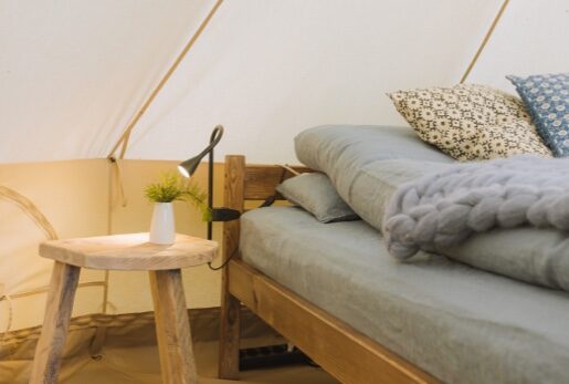 bed and bedside table in a tent